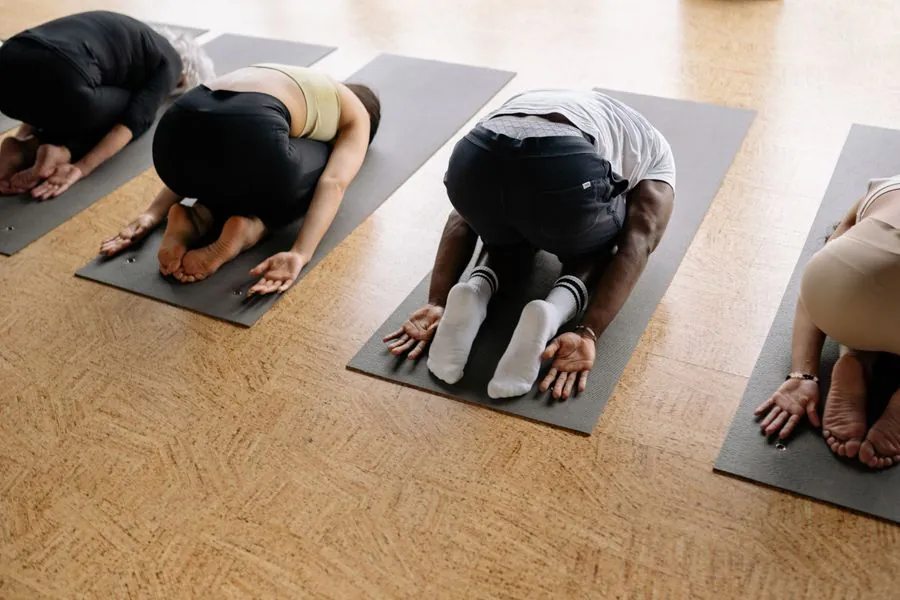 People in child's pose on mats seen from above